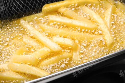 Preview: Cooking delicious french fries in hot oil, closeup