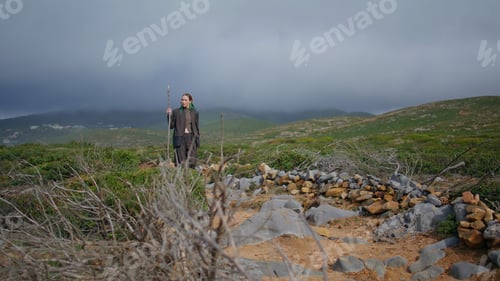 Preview: Serene woman hiking mountains at overcast sky. Trail tourist walking green hill