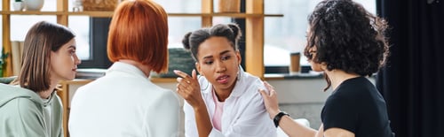 Preview: upset african american woman talking to motivation coach and multicultural female friends during