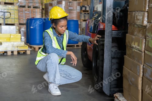 Preview: woman work in warehouse wearing hi visible vest look at forklift puncher flat tire not drive