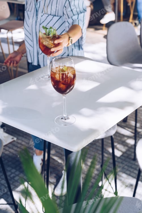 Preview: Woman is holding a glass of cocktail, summer days.