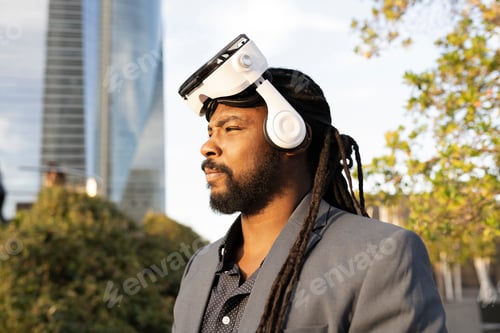 Preview: Afro man stands in serious profile while wearing virtual reality glasses