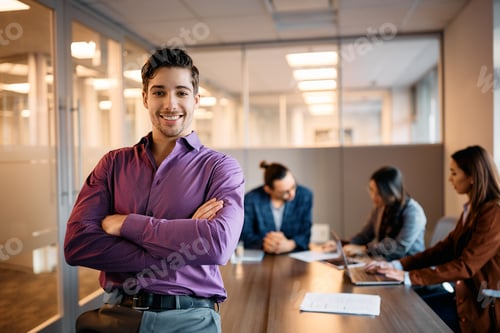 Preview: Happy Hispanic gay businessman with crossed arms in the office looking at camera.