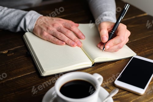 Preview: Woman writing by left hand in notebook