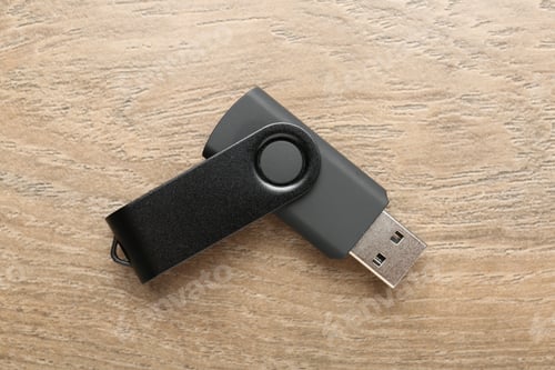 Preview: One flash drive on wooden background, top view