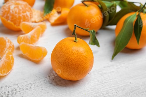 Vorschau: Frische reife Mandarinen mit grünen Blättern auf dem Tisch
