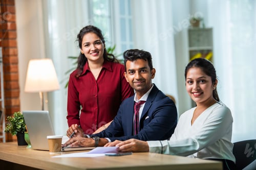 Preview: Indian young businesspeople using laptop in group meeting at desk