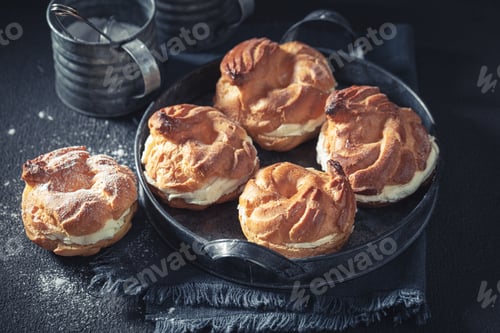Preview: Yummy and sweet cream puffs on rustic dark table