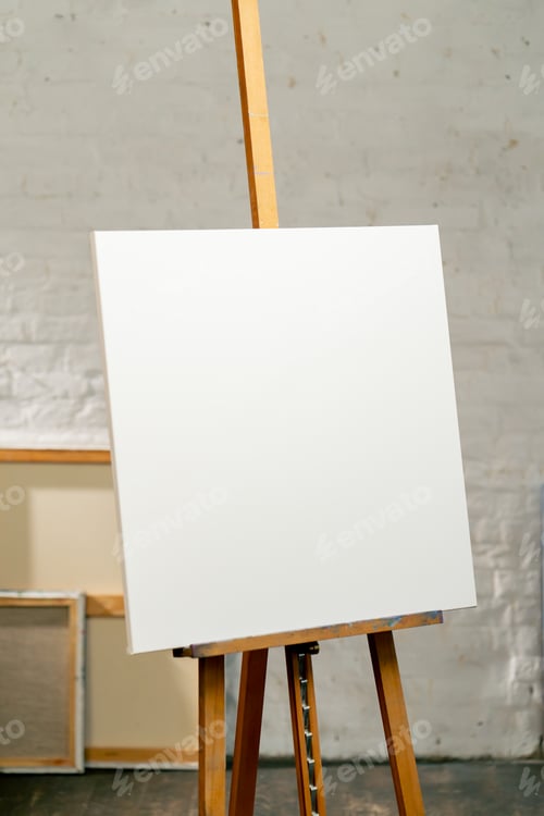 Preview: close up in an art studio there is a tripod with a large white and blank canvas next to a box
