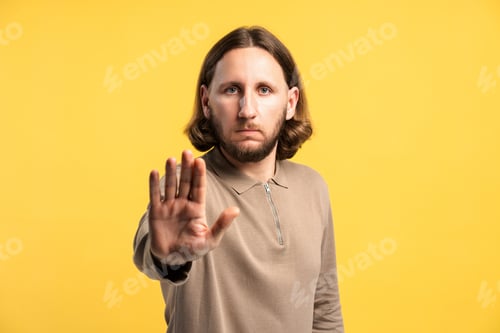 Preview: Man making stop gesture signaling refusal, warning, or denial