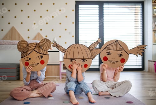 Preview: Portrait of three girls sisters indoors at home, playing