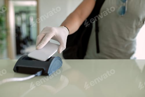 Preview: Close-up of athlete using smart phone while checking in at health club.