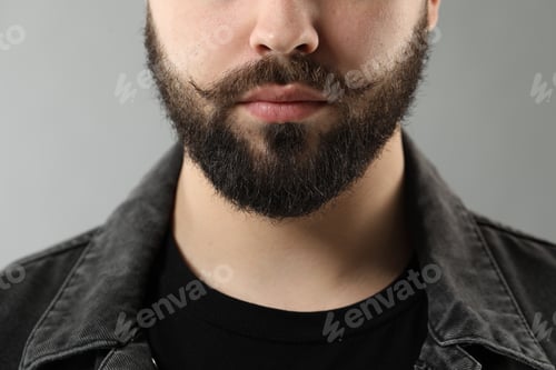 Preview: Handsome young man with mustache on grey background, closeup