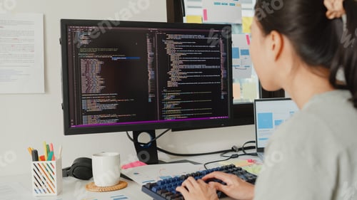 Preview: Programmer typing on keyboard coding programming fixing database code on computer monitor.