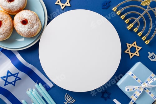 Preview: Hanukkah celebration table decor. Overhead photo of classic sufganiyot, plates, Star of David