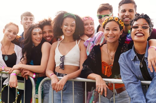 Preview: Portrait Of Young Friends In Audience Behind Barrier At Outdoor Music Festival