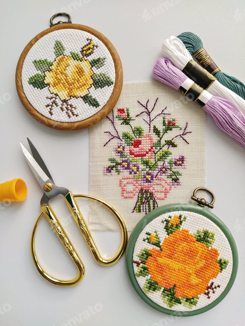 Preview: Vintage wooden embroidery hoops, scissors, needle, thread and fabric with floral cross-stitch embroi
