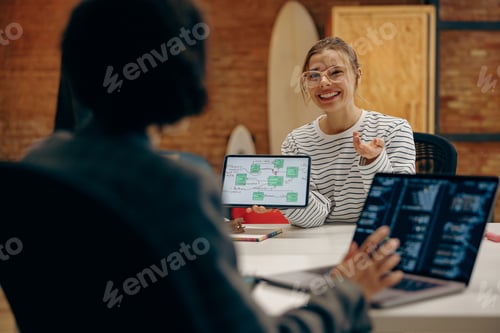 Preview: Business partners having meeting in coworking. Female colleagues having discussion over tablet pc