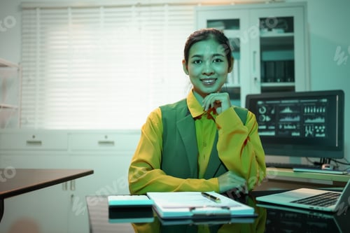 Preview: Asian businesswoman celebrating success at her desk, delighted after achieving business goals