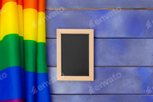 Preview: Bright rainbow gay flag on wooden background and blank space