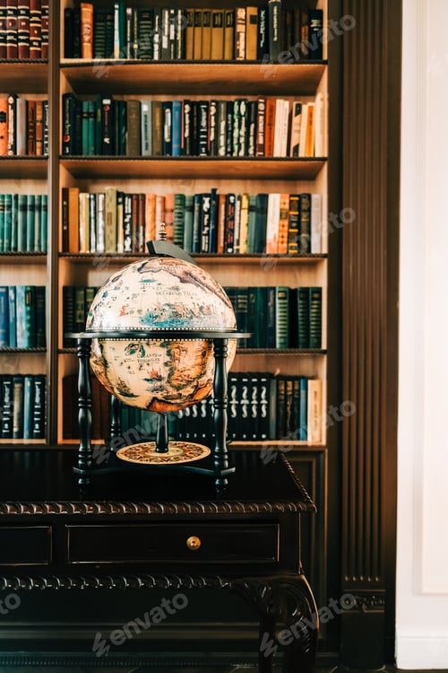 Preview: Big wooden vintage globe in a table near bookshelf in library.