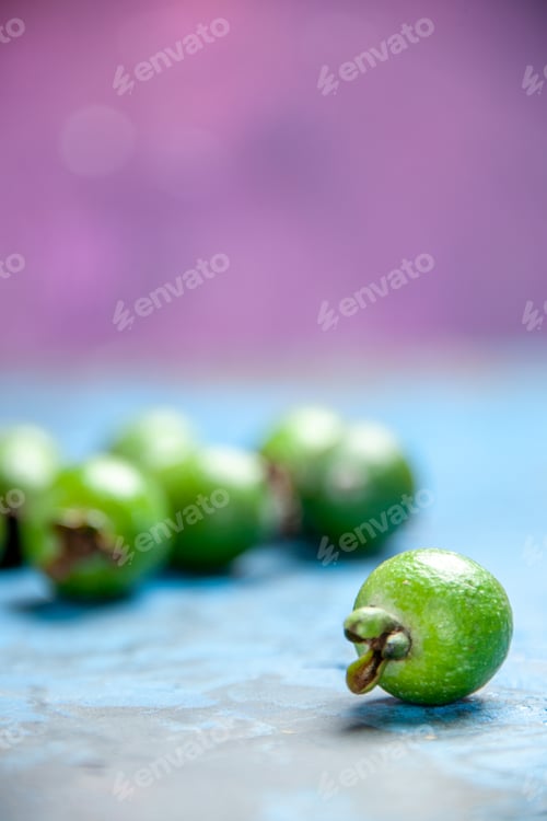 Preview: Vertical view of fresh natural delicious green feijoas on blue background