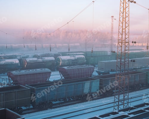 Preview: early morning railways station with freight trains at snowy cold winter time, blizzard frosty