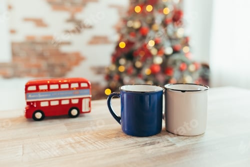 Preview: close-up photo of two Christmas cups, on New Year's background, Christmas tree and colorful lights