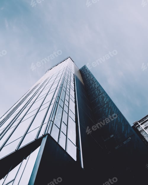Preview: Vertical low angle shot of a high rise building in a glass facade