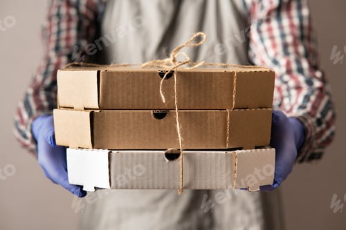 Preview: Boxes of care in the hands of a man. Contactless delivery during quarantine and coronavirus pandem
