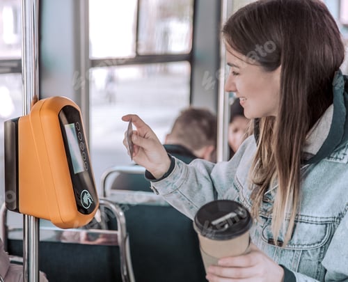Preview: A young woman contactless pays for public transport.