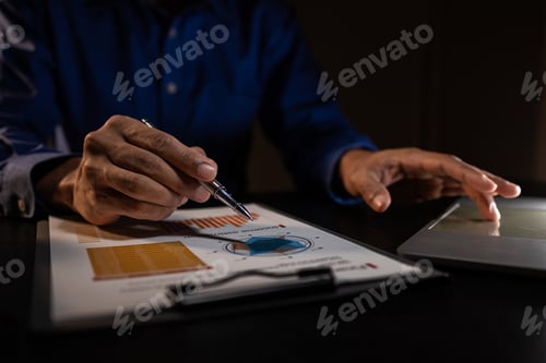 Preview: a businessman works overtime is his accounting firm's office until late at night
