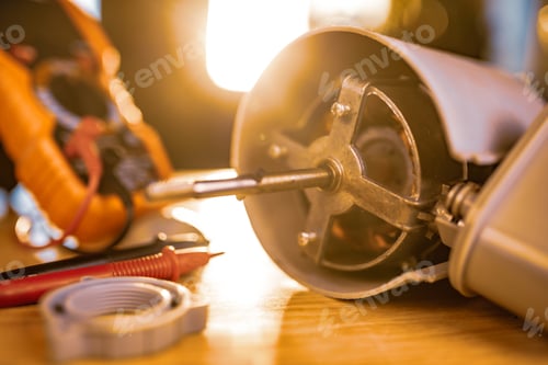 Preview: Close-up of iron motor from home cooling fan lies on a table under repair