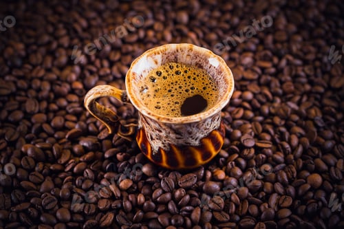 Preview: Cup of coffee on roasted coffee beans.