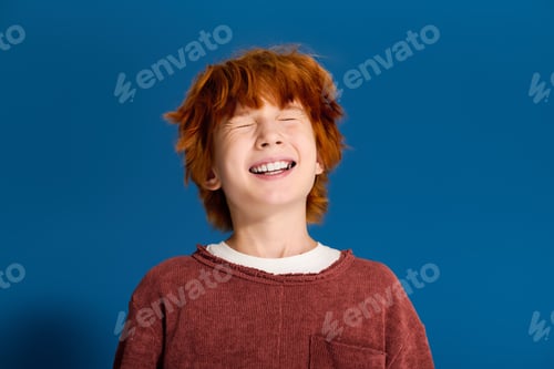 Preview: Joyful redhead boy enjoying a playful moment in a bright studio setting