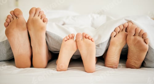 Preview: Feet, family and sleeping on bed in bedroom of home together for rest, relax and comfort in the mor