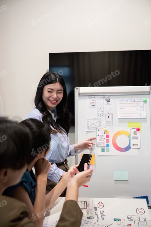 Preview: ux developer and ui designer presenting and testing mobile app interface design on whiteboard in