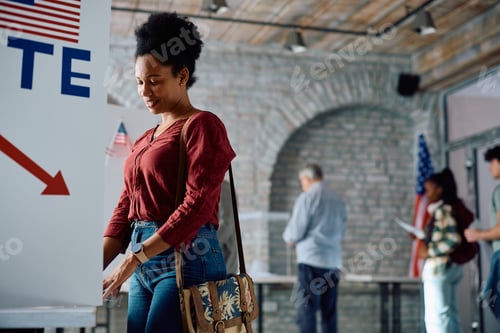 Preview: African American woman at voting booth during US elections.