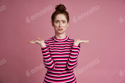 Preview: Studio shot of young woman shrugging her shoulders