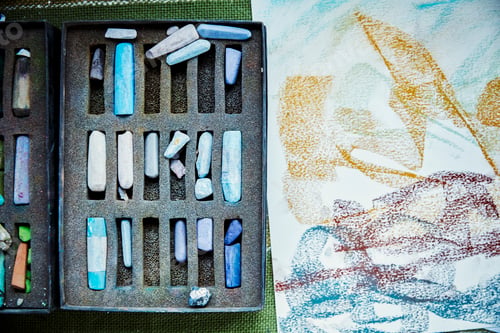 Preview: An artist's canvas with an artwork in progress, and box of pastels, colours.