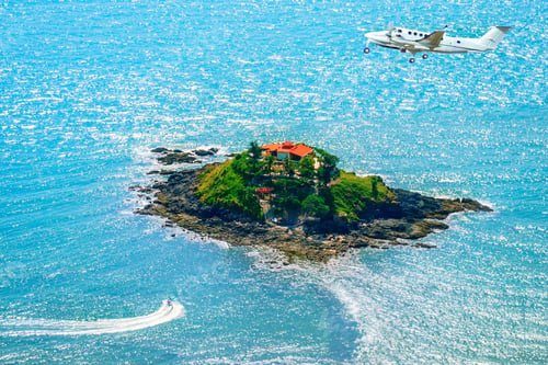Preview: Jet flies above a small island in the sea
