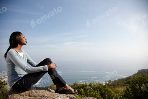Preview: Woman relaxing on mountain top