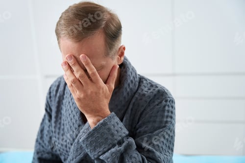 Preview: Upset middle-aged patient sits in a bright room