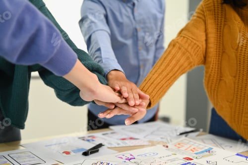 Preview: Cropped shot of startup businesspeople stacking hands together, celebrating completion of project.