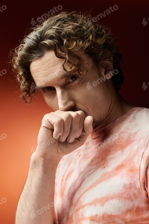 Preview: Handsome Man Expressing Emotion Against Vibrant Red Background at Dusk