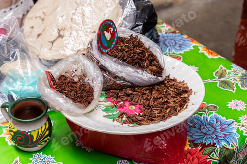 Preview: Fresh fried and salted grasshoppers from Oaxaca (translation: chapulines) on a colorful table