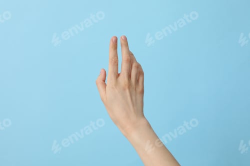 Preview: Female well-groomed hand on a light blue background
