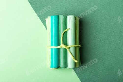 Preview: A few pastel crayons tied with a ribbon on green pastel paper. Green palette