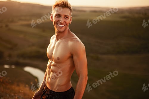 Preview: Cheerful shirtless sportsman smiling after successful outdoor training in nature