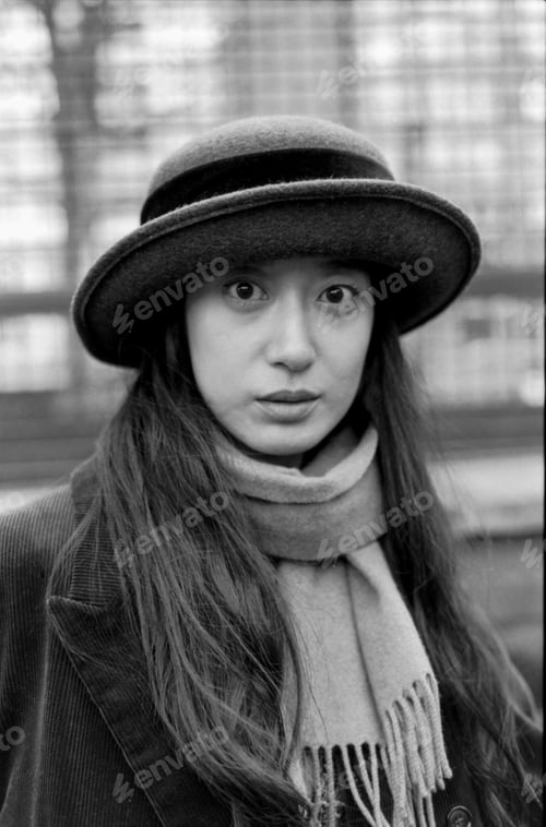 Preview: Young woman wearing hat and scarf posing in monochrome analog portrait